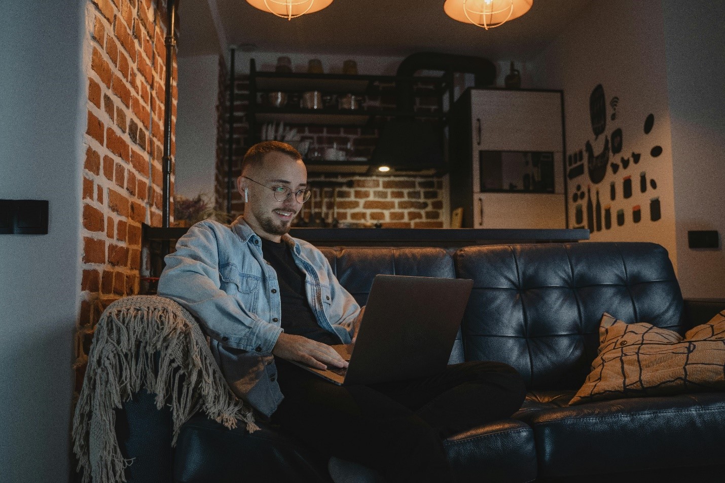 A content young man on a laptop, smiling as he enjoys his secure WiFi